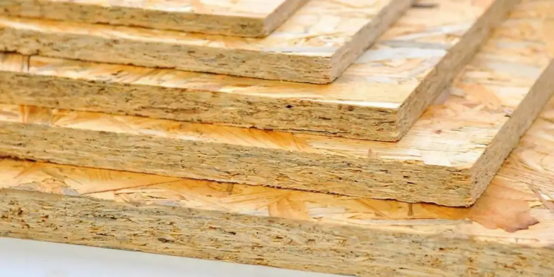 Stos płyt OSB na dach, jaka grubość? Widoczne warstwy płyt OSB, idealne do budowy dachu.