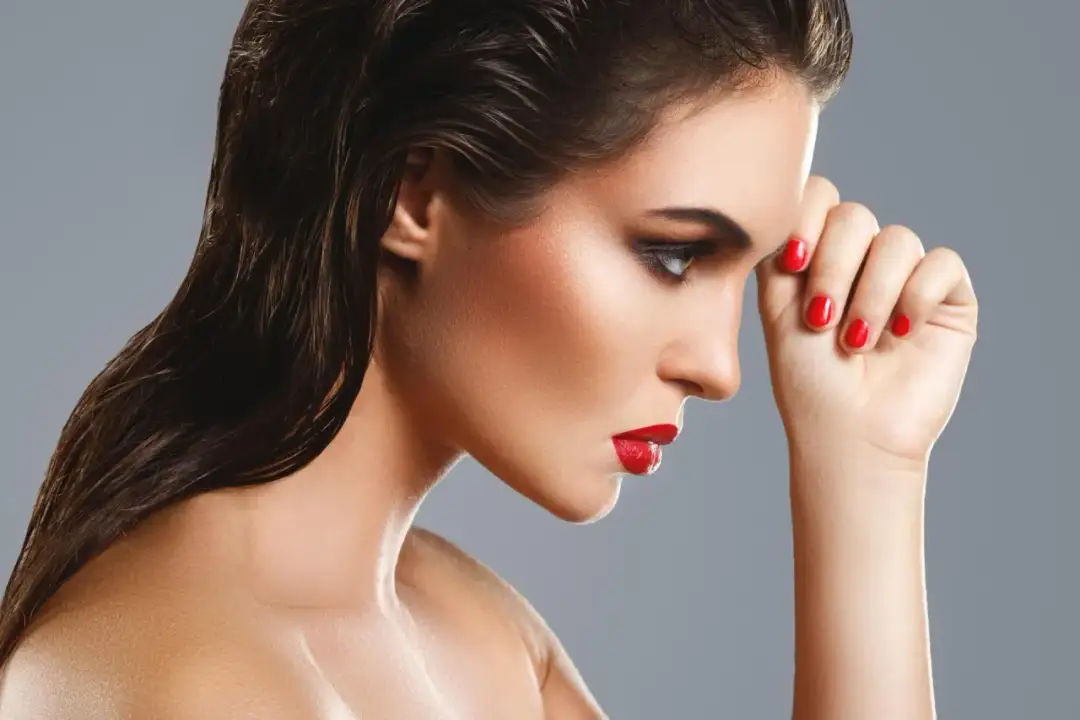 Kobieta z mokrymi włosami i wyrazistym makijażem, jak zrobić mokrą włoszkę. Czerwone usta i paznokcie.