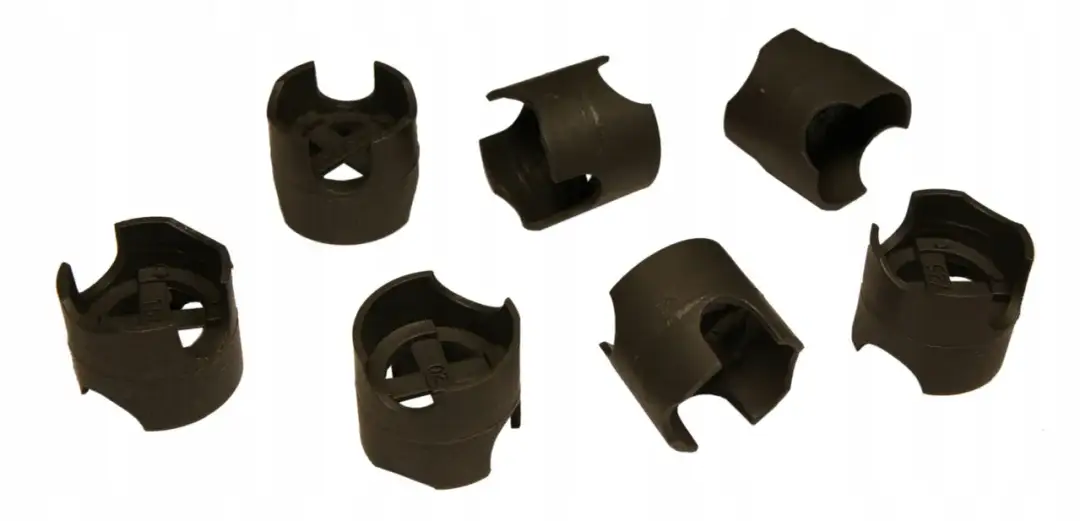 Siedem czarnych plastikowych podstawek pod zbrojenie na białym tle.
