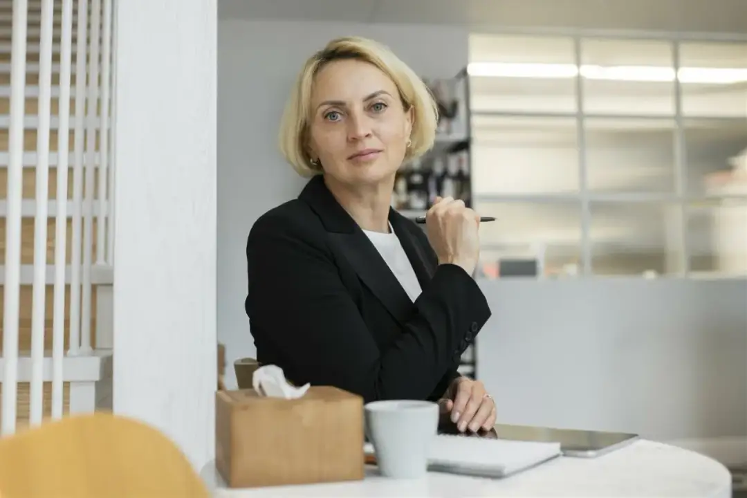 Pani dyrektor szkoły, z piórem w dłoni, wygląda na skupioną. Może właśnie przyznaje nagrodę dyrektora szkoły.