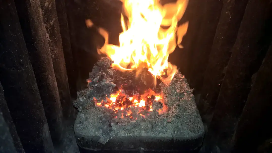 Żarzące się węgle i płomienie w piecu, pokazujące, jak palić miał w zwykłym piecu.