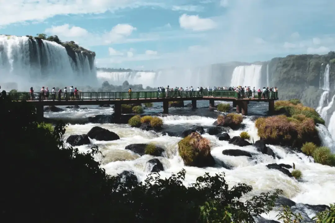 Most wodospadów Iguazú z platformą widokową i turystami.