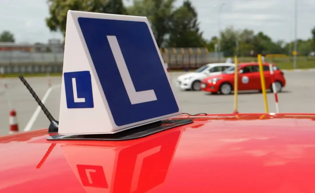 Znak "L" na dachu czerwonego auta. Zastanawiasz się, ile pytań jest na egzaminie teoretycznym?