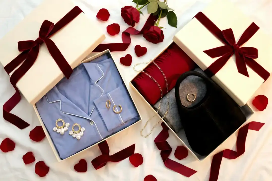 Eleganckie prezenty na walentynki: błękitna piżama, czerwony szal, czarna torebka i biżuteria.