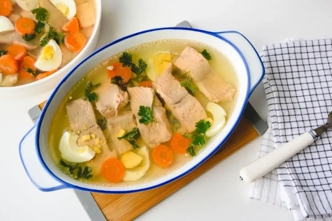 Przezroczysta galaretka z rybą, jajkiem i marchewką. Aby uzyskać taki efekt, kluczowe jest dokładne odcedzenie wywaru.