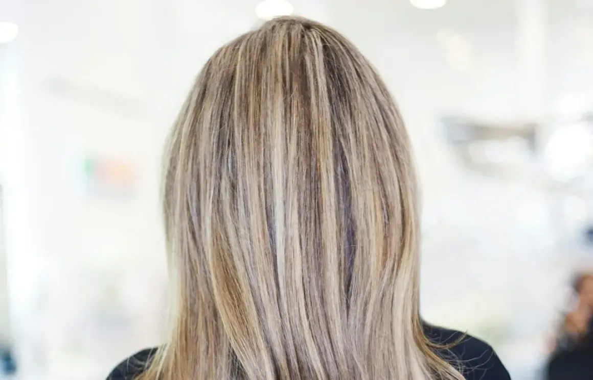 En frisyr med brunt hår med kalla slingor som ger en naturlig och modern look.