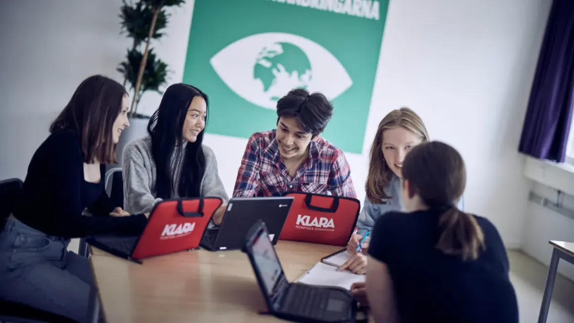 Elever på Klara Norra gymnasium samarbetar kring laptops.