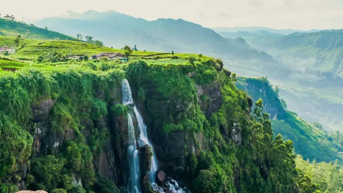 Wodospad na zielonym klifie, plantacje herbaty i domki na wzgórzu. Widok zapierający dech w piersiach, idealny na wiza Sri Lanka.
