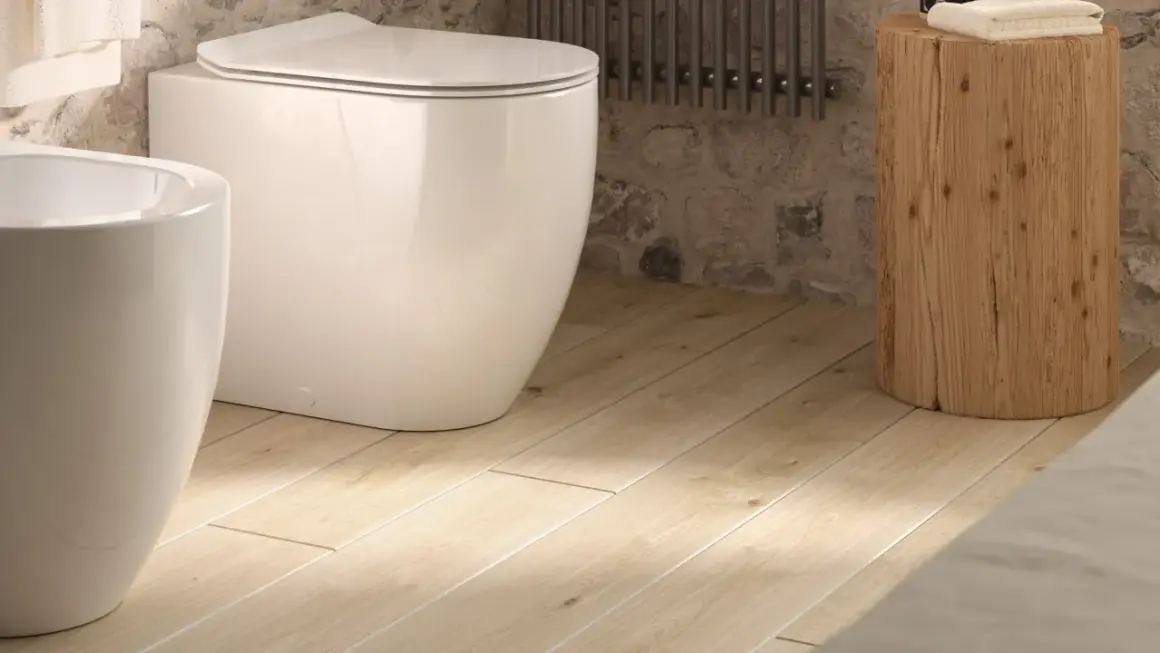 Bagno moderno con vaso e bidet bianchi su un caldo pavimento in pvc per bagno, opinioni positive per questo stile.