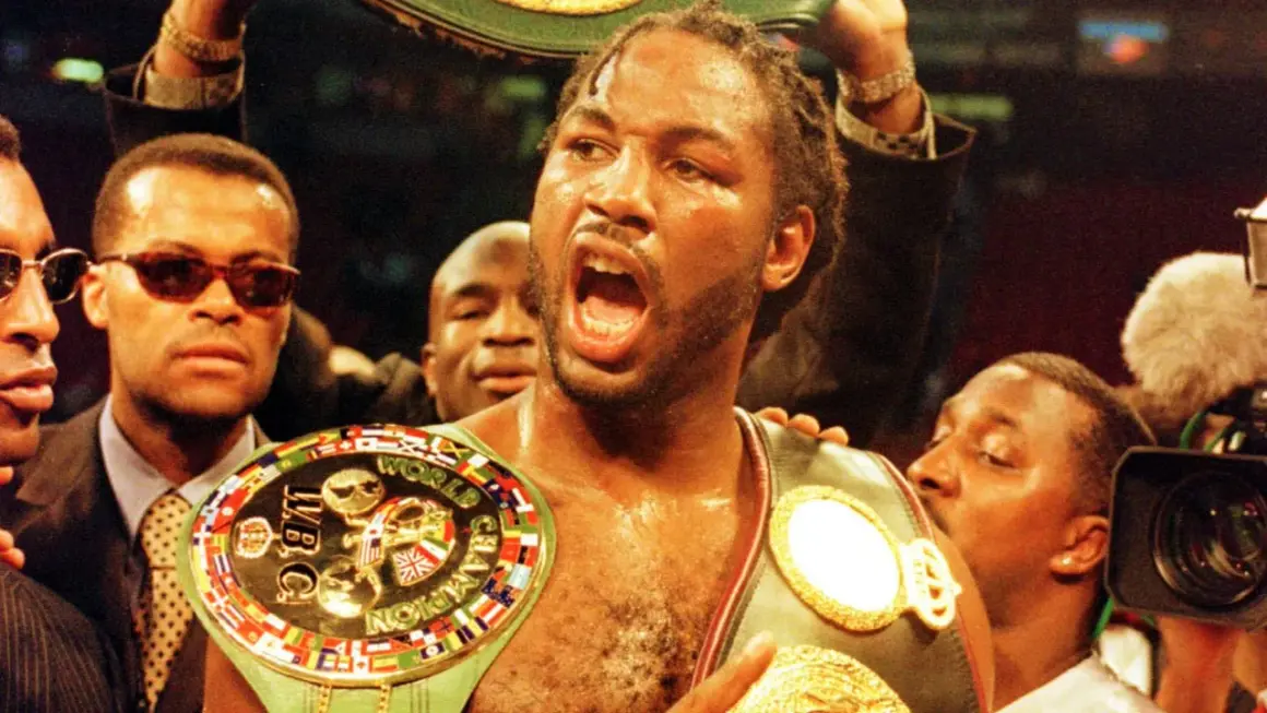 Lennox Lewis, triumphant, wears multiple championship belts, a symbol of his boxing dominance.