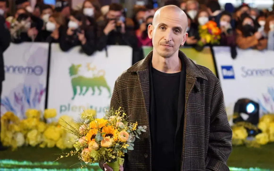 Un uomo con un mazzo di fiori, forse pensando ai testi di Fabrizio De André nella sua ora di libertà.