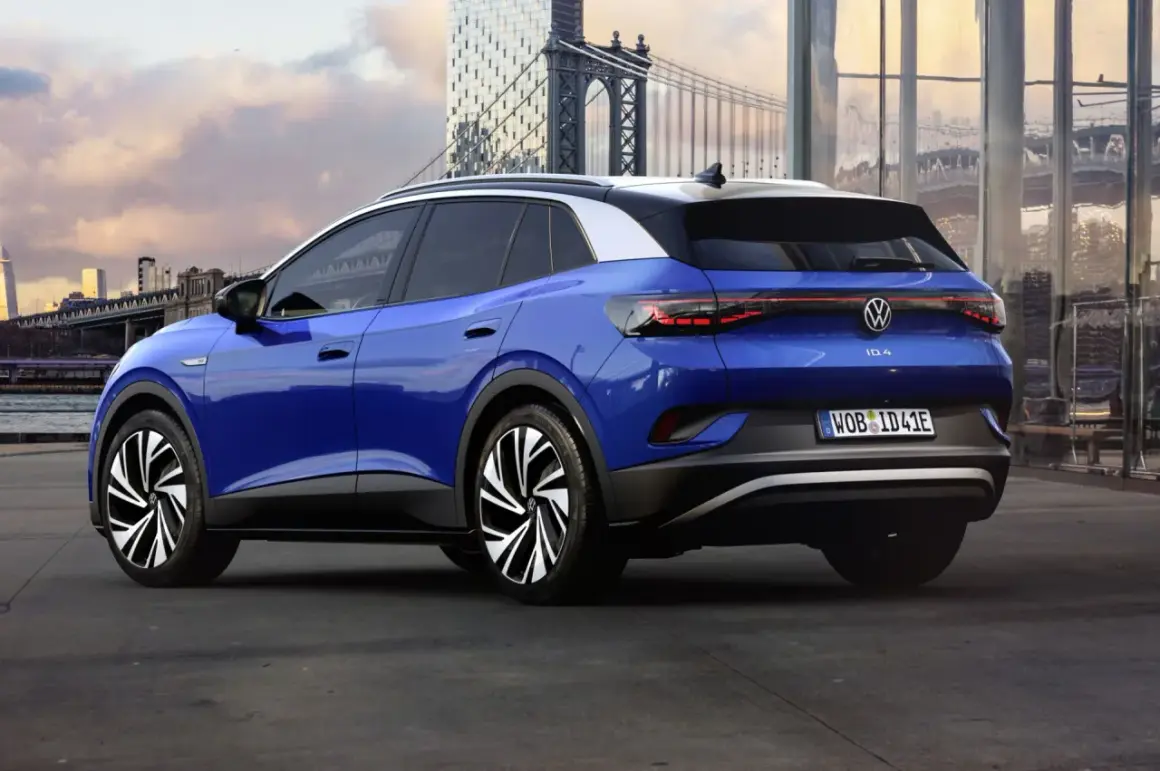 Niebieski VW ID.4 z imponującym zasięgiem, zaparkowany na tle miejskiego krajobrazu z mostem w tle.