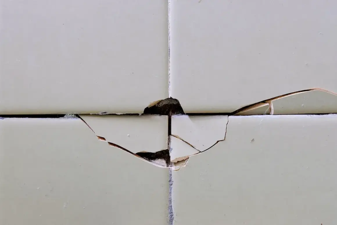 Dettaglio di piastrelle scheggiate, un problema comune per chi cerca come riparare piastrelle scheggiate.