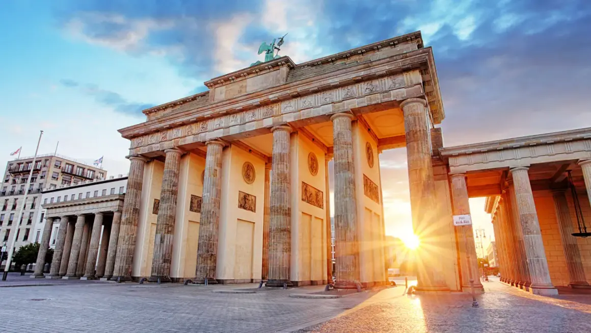 Brandenburger Tor i Berlin, en ikonisk symbol för staden, perfekt för din berlin reseguide. Solnedgången lyser upp monumentet.