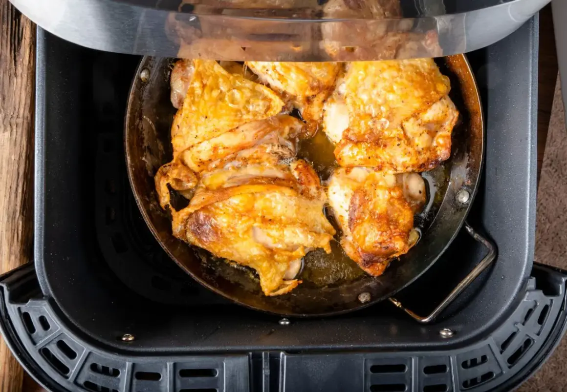 Pechuga de pollo dorada y jugosa cocinándose en una freidora de aire.