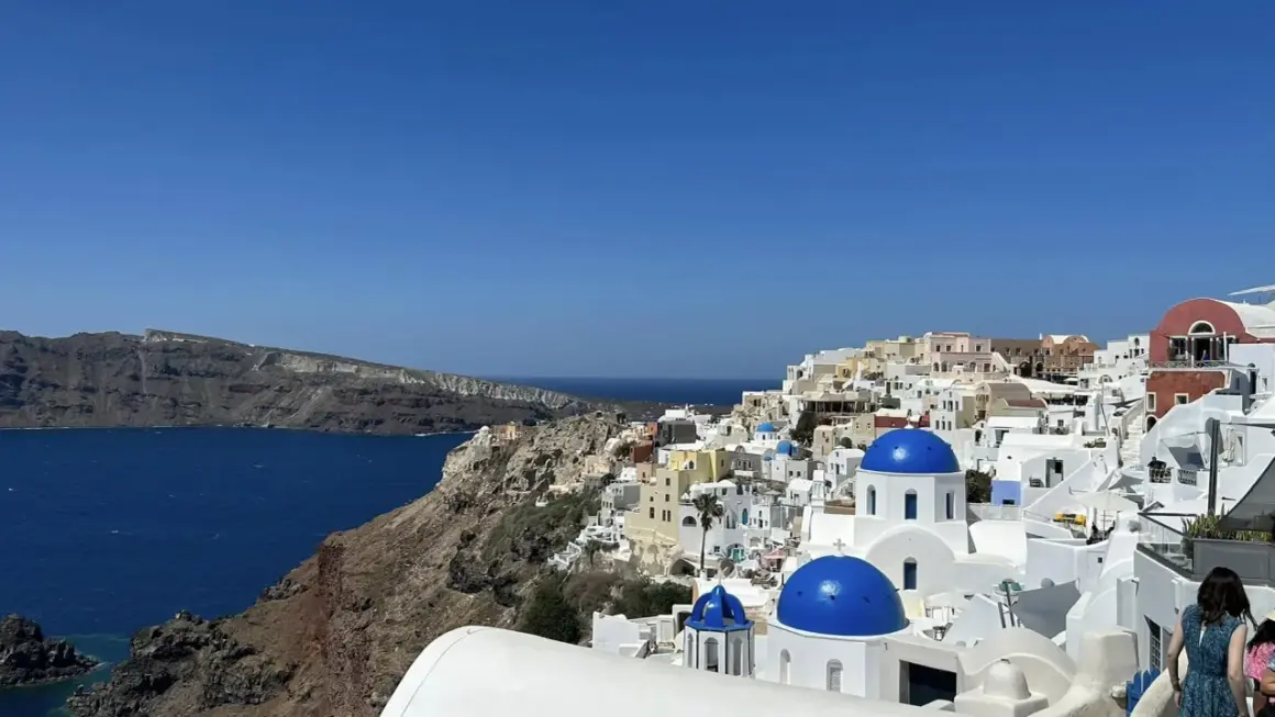 Widok na białe domy z niebieskimi kopułami na Santorini. Idealne miejsce na niezapomniane wycieczki.