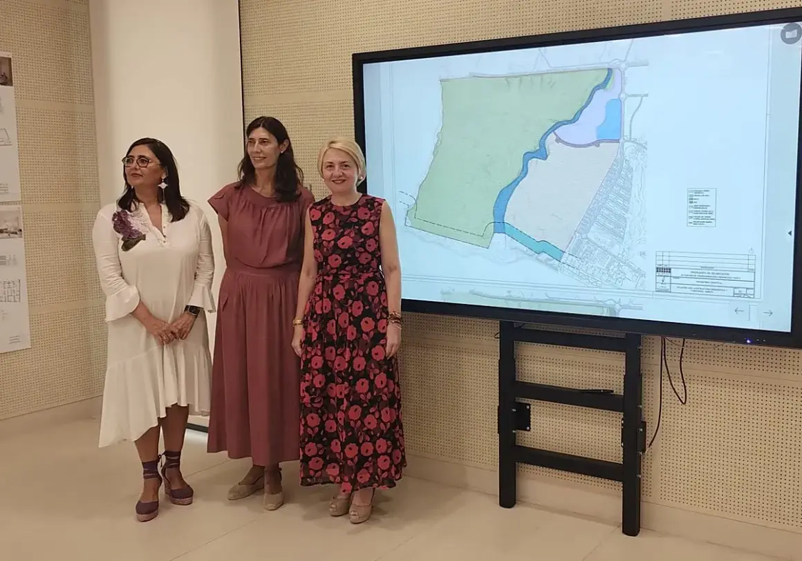 Tres mujeres observan un plano en pantalla grande, posiblemente sobre el proyecto **el toyo Almería**.