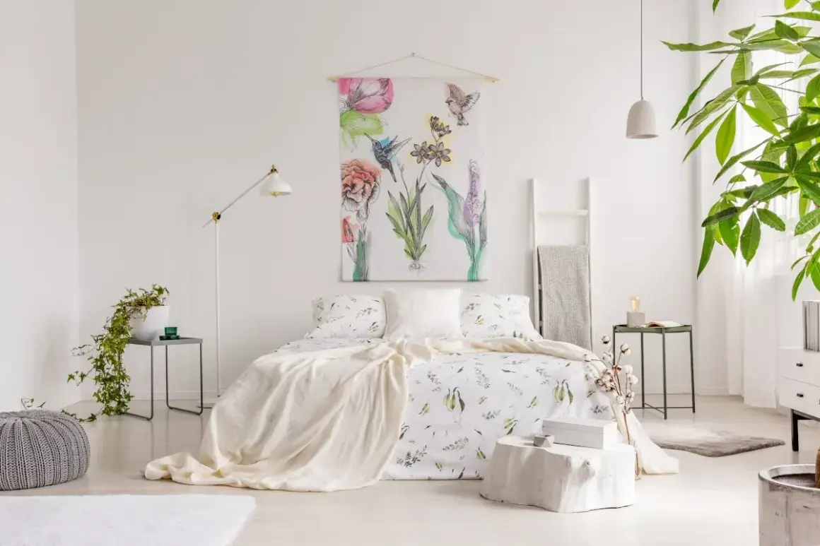 Sypialnia w stylu shabby chic z pościelą w kwiaty, narzutą i obrazem z ptakami i kwiatami.