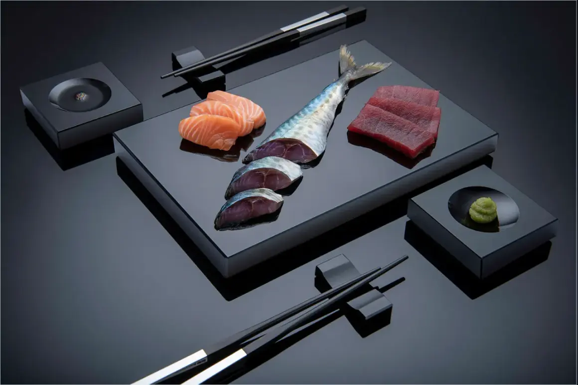 Sashimi-Zutaten: Lachs, Thunfisch, Makrele, Wasabi und Stäbchen. Die Frage "aus welchem Land kommt Sushi" führt uns nach Japan.