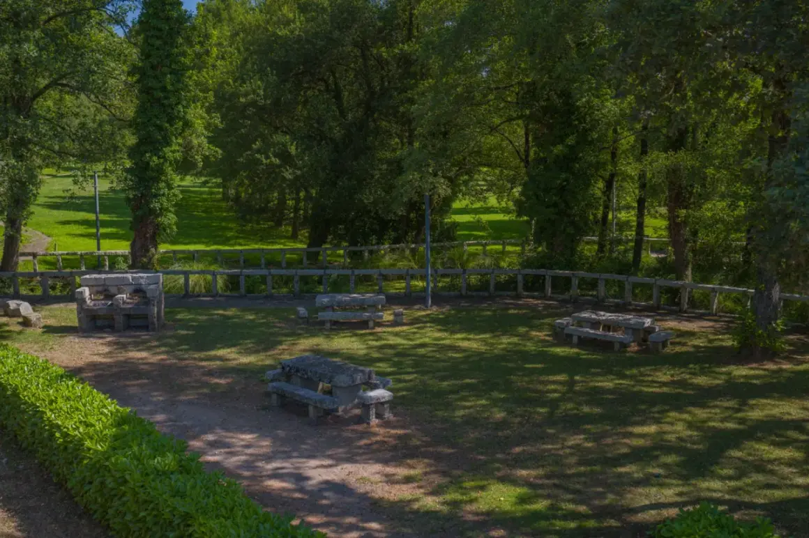 Área recreativa con mesas de piedra y barbacoa, un lugar idílico cerca del nacimiento del Miño.