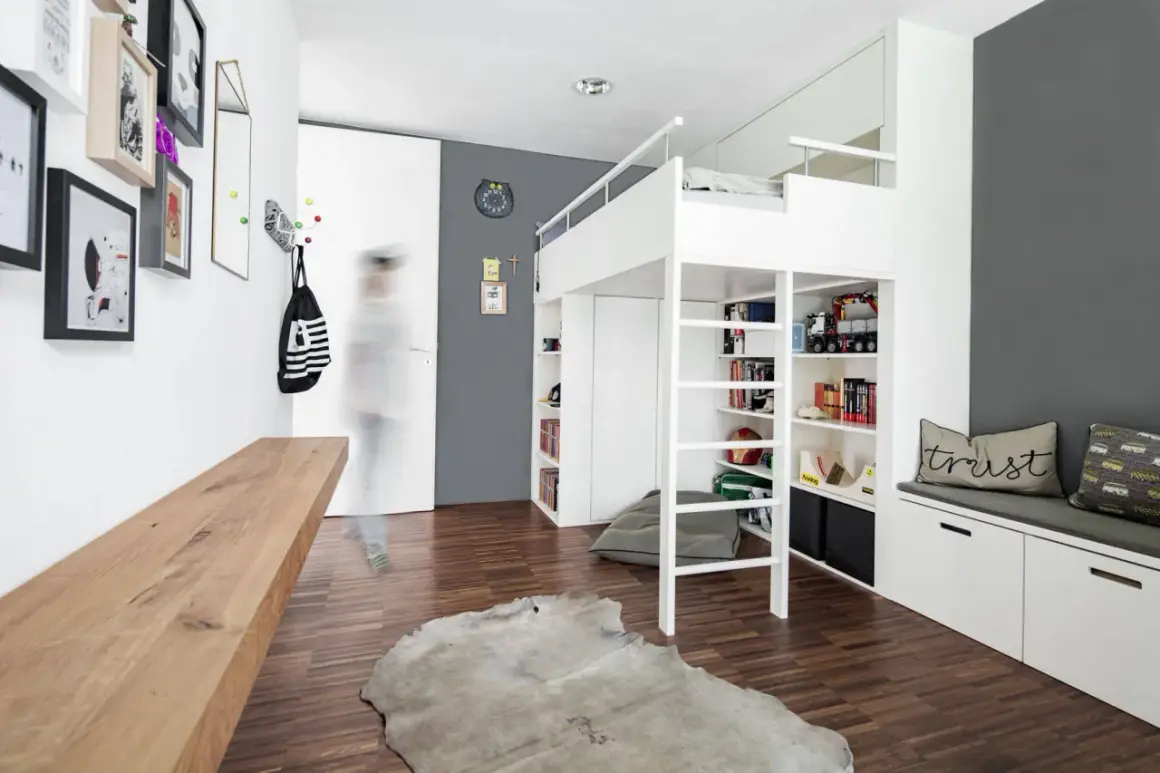 Cleverer Stauraum im Kinderzimmer: Hochbett mit integrierten Regalen und Schränken, DIY-Bank und Wandhaken für Ordnung.
