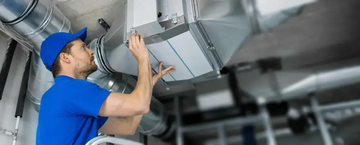 Installatör byter filterduk i ventilationssystem. Ren luft är viktigt för hälsan.