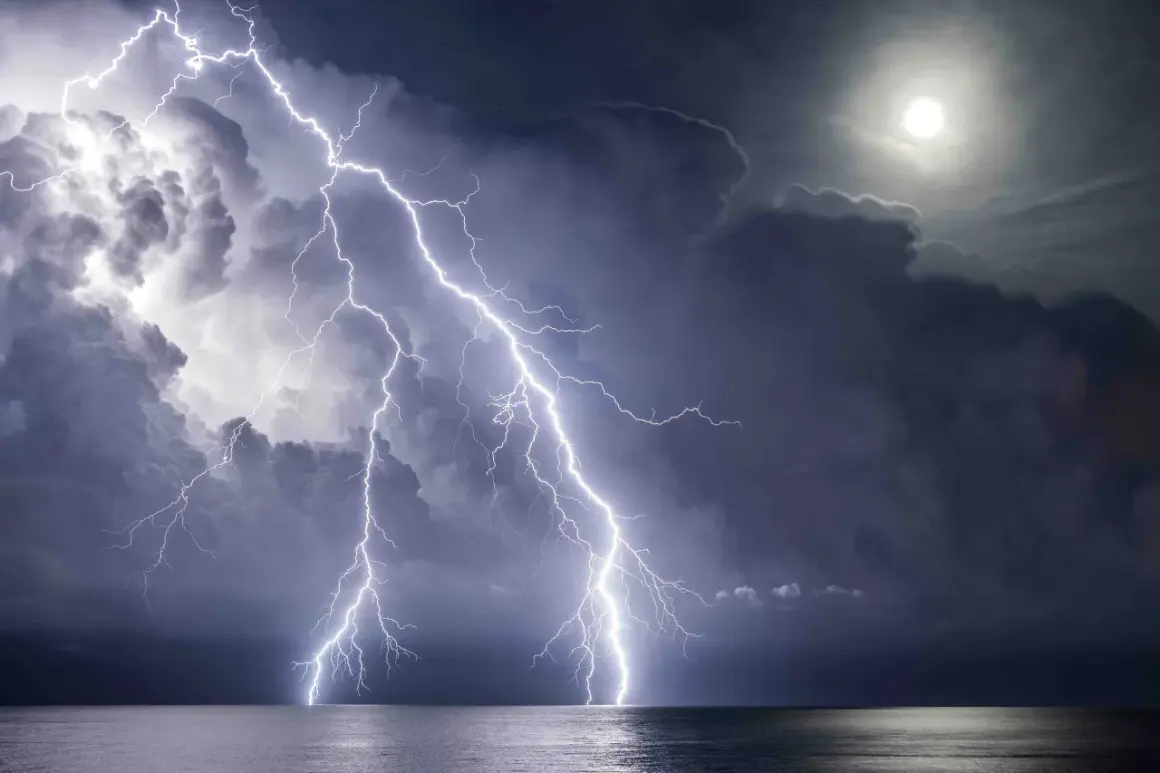 Dramatic lightning photography captures multiple bolts striking the ocean under a stormy sky with a bright moon.
