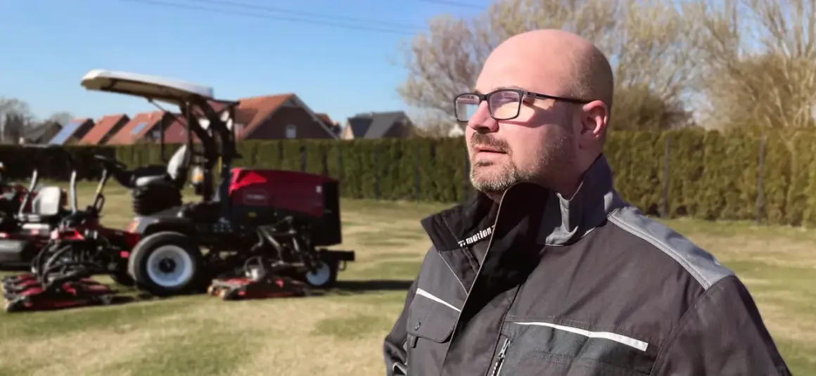 Mann mit Brille, der auf Rasenmäher blickt. Neue Wege für Quereinsteiger in Berufe in der Natur.