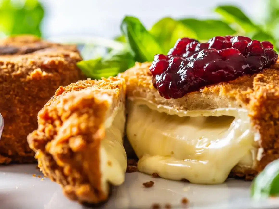 Chrupiący camembert w panierce, z rozpływającym się serem w środku, polany konfiturą z owoców leśnych. Idealny na przekąskę.