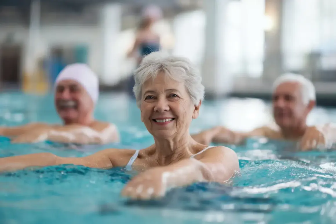 Des seniors souriants participent à un programme de mise en forme aquatique, profitant des bienfaits de l'eau pour leur bien-être.