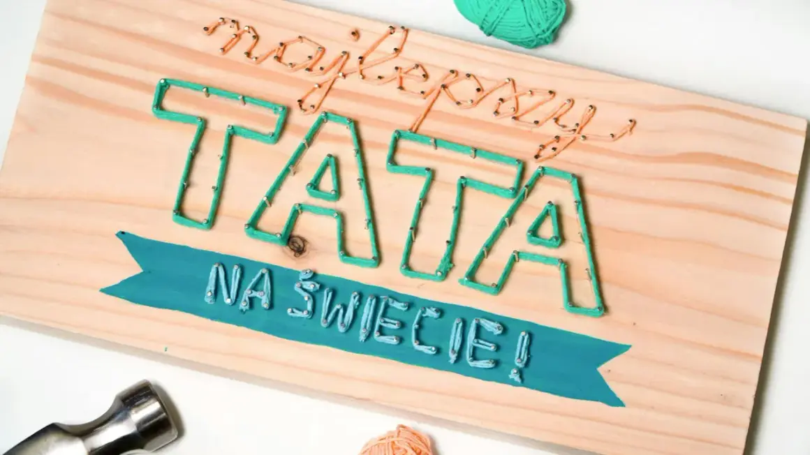 Jak zrobić własnoręcznie prezent na Dzień Ojca: tablica z napisem "Najlepszy TATA na świecie" wykonana techniką string art.