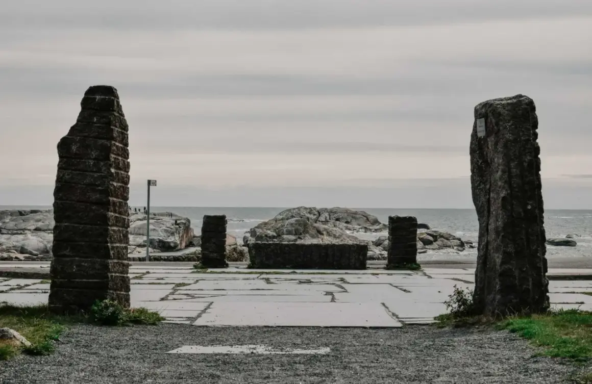 Kamienne filary i kamienna ława na placu przy morzu, jakby na **verdens ende**.