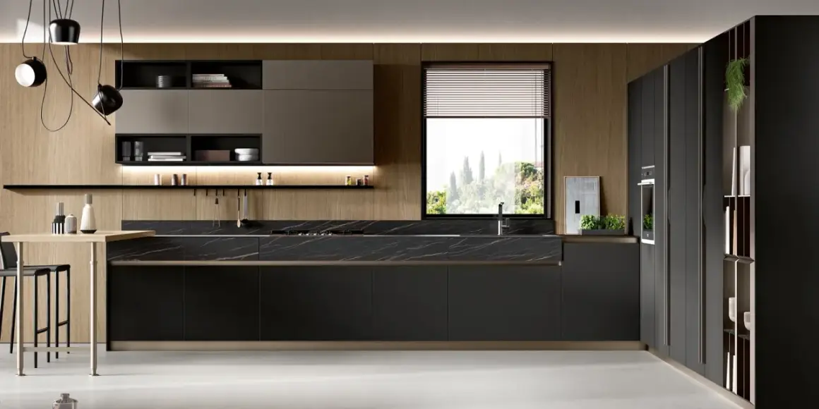 Cucina moderna con pensili in legno, piano in marmo nero e una grande finestra che si affaccia su un paesaggio verdeggiante.