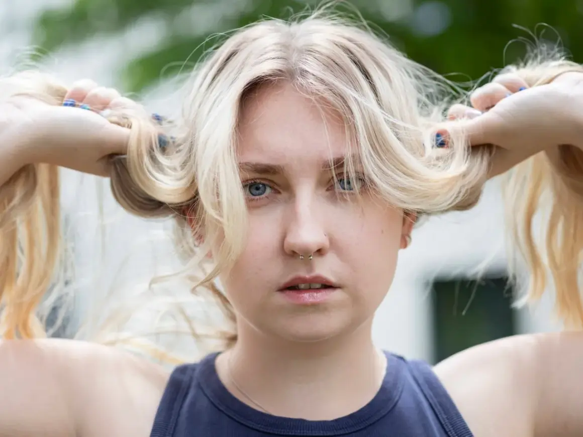 Blondes Haar, das mit Kamillentee behandelt wurde, zeigt vorher-nachher-Effekte. Die Frau hält ihre blonden Zöpfe hoch.