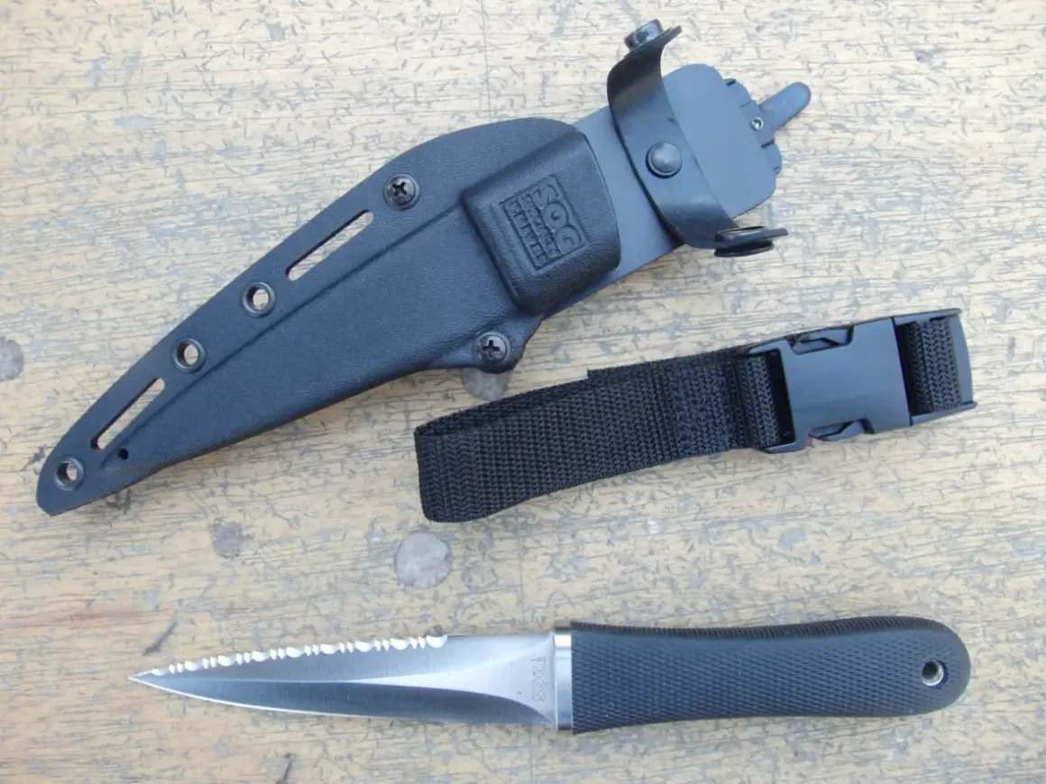 Daga táctica SOG con funda negra y correa de sujeción. Hoja de acero con sierra.