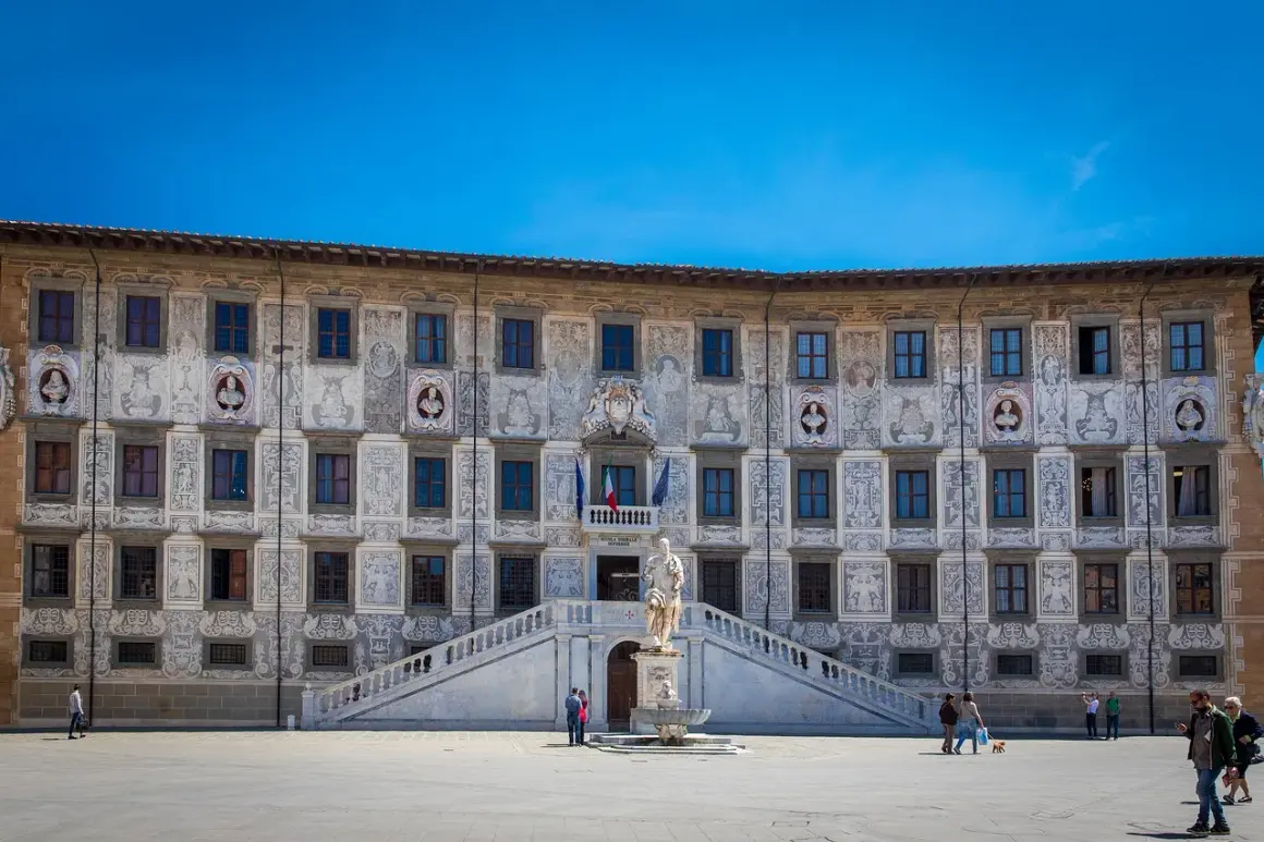 Piazza dei Cavalieri a Pisa: un palazzo storico con affreschi, una statua e una fontana. Cosa vedere a Pisa? Questo è un must!