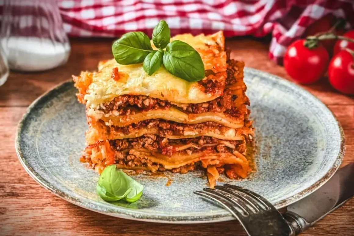 Ein Stück Lasagne mit Hackfleisch, belegt mit frischem Basilikum. Ein köstliches lasagne rezept mit hackfleisch.