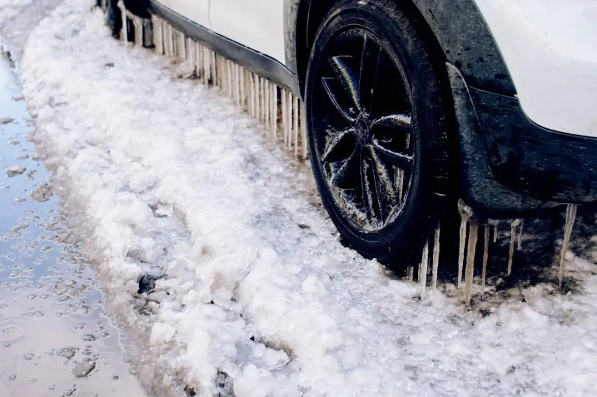 Lodowe sople zwisają z progu samochodu, który utknął w śniegu. Diesel potrzebuje samostartu, by ruszyć.