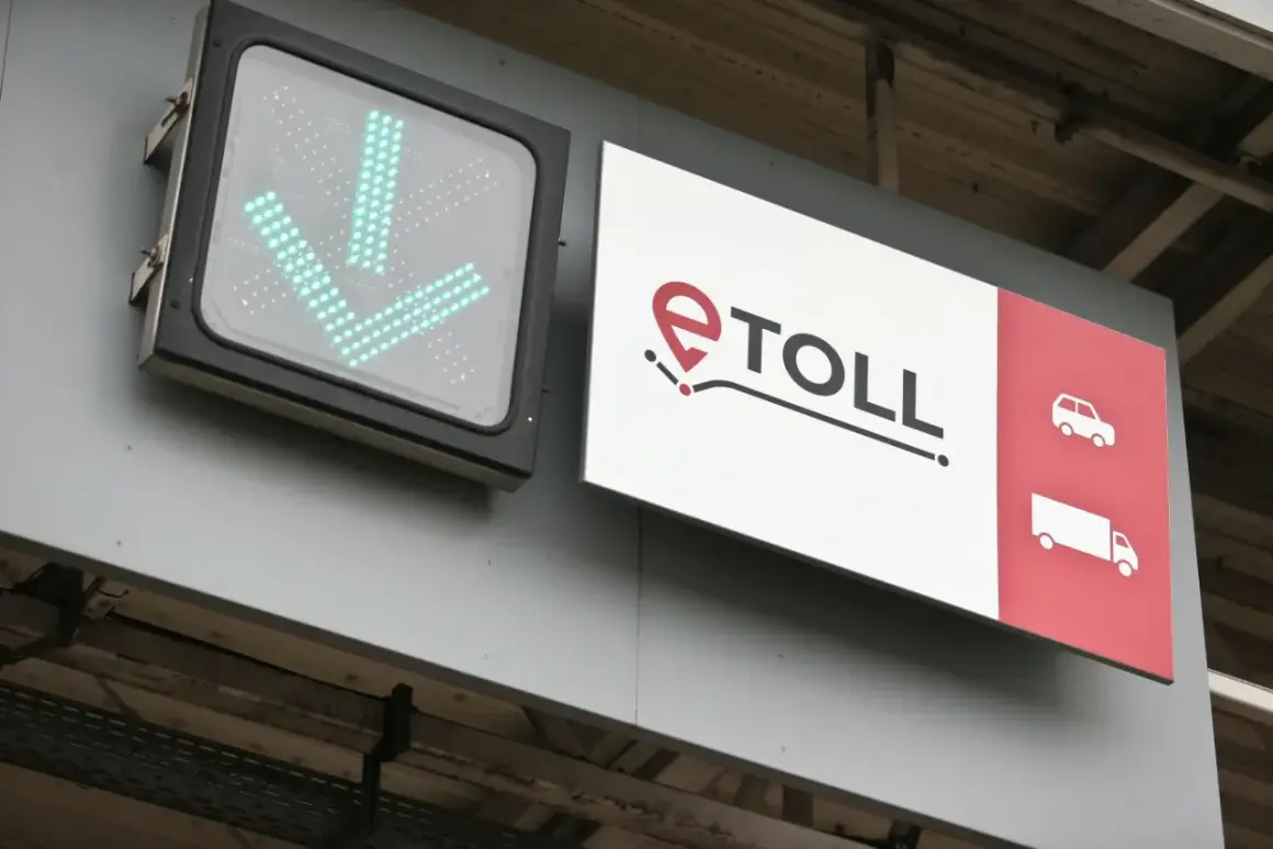 Znak e-TOLL z zielonymi strzałkami w dół i ikonami pojazdów.