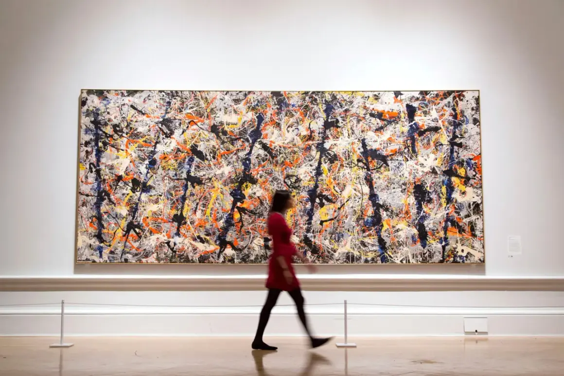 A woman in a red dress walks past a large, vibrant canvas of contemporary abstract expressionism, a masterpiece of splattered paint.
