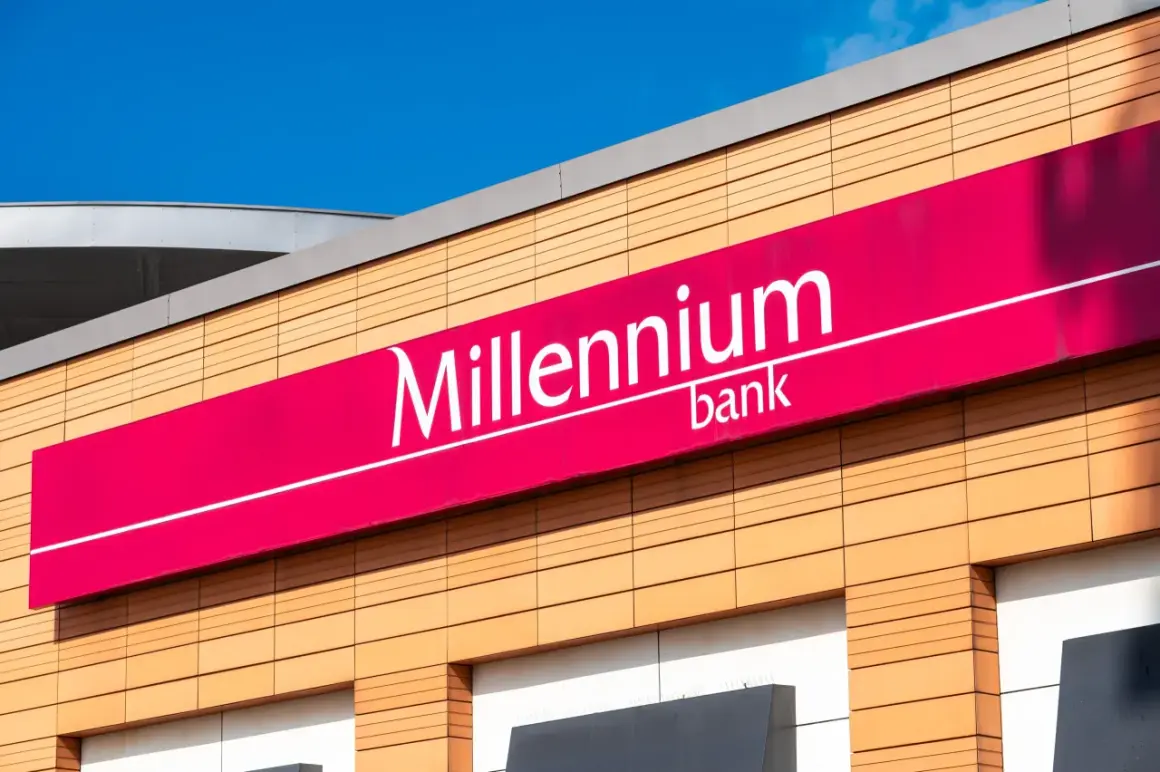 Elegancki budynek z logo Millennium bank. Jasne panele elewacyjne i fuksjowy baner z nazwą banku.