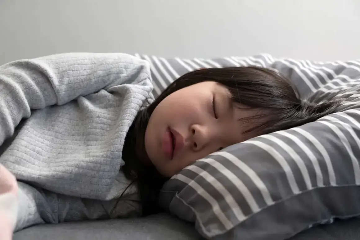 Ein kleines Mädchen schläft tief und fest. Wie lange machen Kinder Mittagsschlaf? Diese Frage beschäftigt viele Eltern.