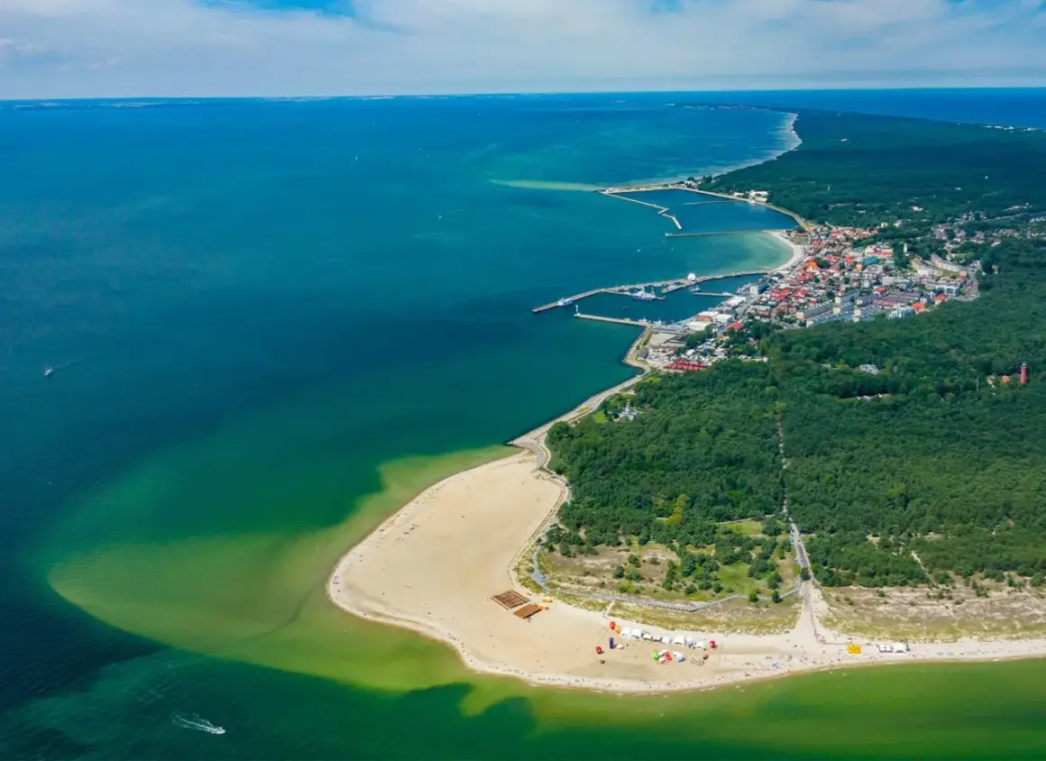 Widok z lotu ptaka na Hel – polskie egzotyczne miejsca z piaszczystą plażą, lasem i portem.