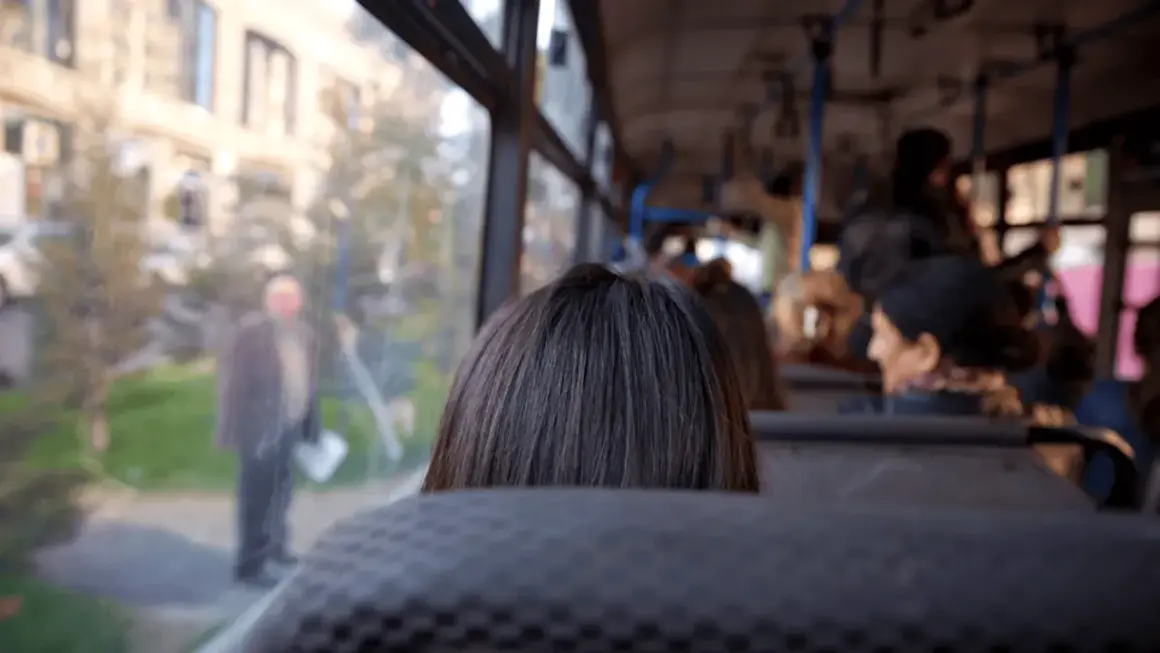 Widok z autobusu na ludzi i budynki. Codzienna podróż do pracy poza miejscem zamieszkania.