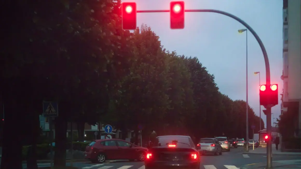 Voitures arrêtées à un feu rouge. La verbalisation camera feu rouge est imminente si le feu passe au vert.