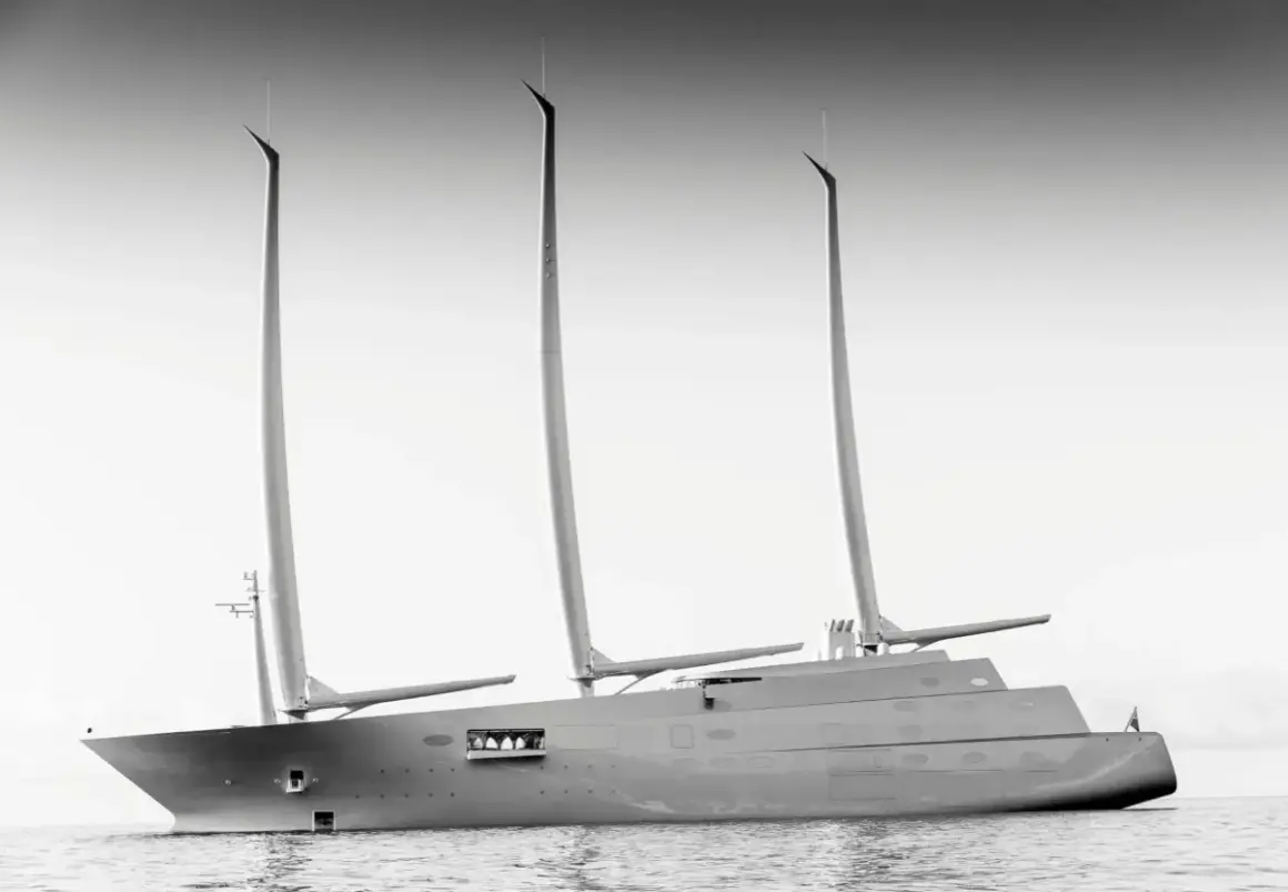 Un maestoso yacht a vela, un'opera di design firmata Philippe Starck, solca le acque con le sue tre imponenti vele.