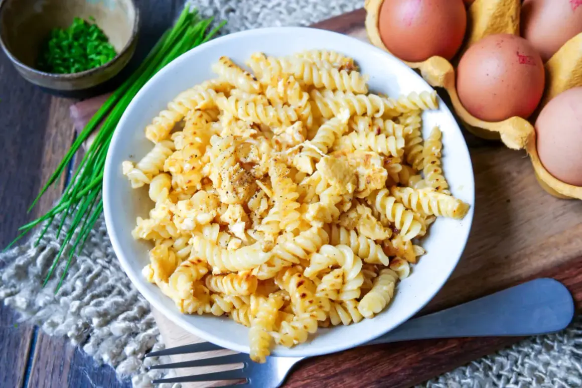 Fusilli-Nudeln mit Rührei, garniert mit Schnittlauch und Pfeffer. Ein einfaches, aber leckeres Gericht: Nudeln mit Ei.
