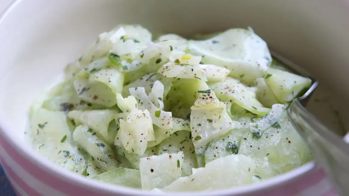 Cremiger Gurkensalat, ein einfaches und erfrischendes gurkensalat rezept, garniert mit Kräutern und Pfeffer.