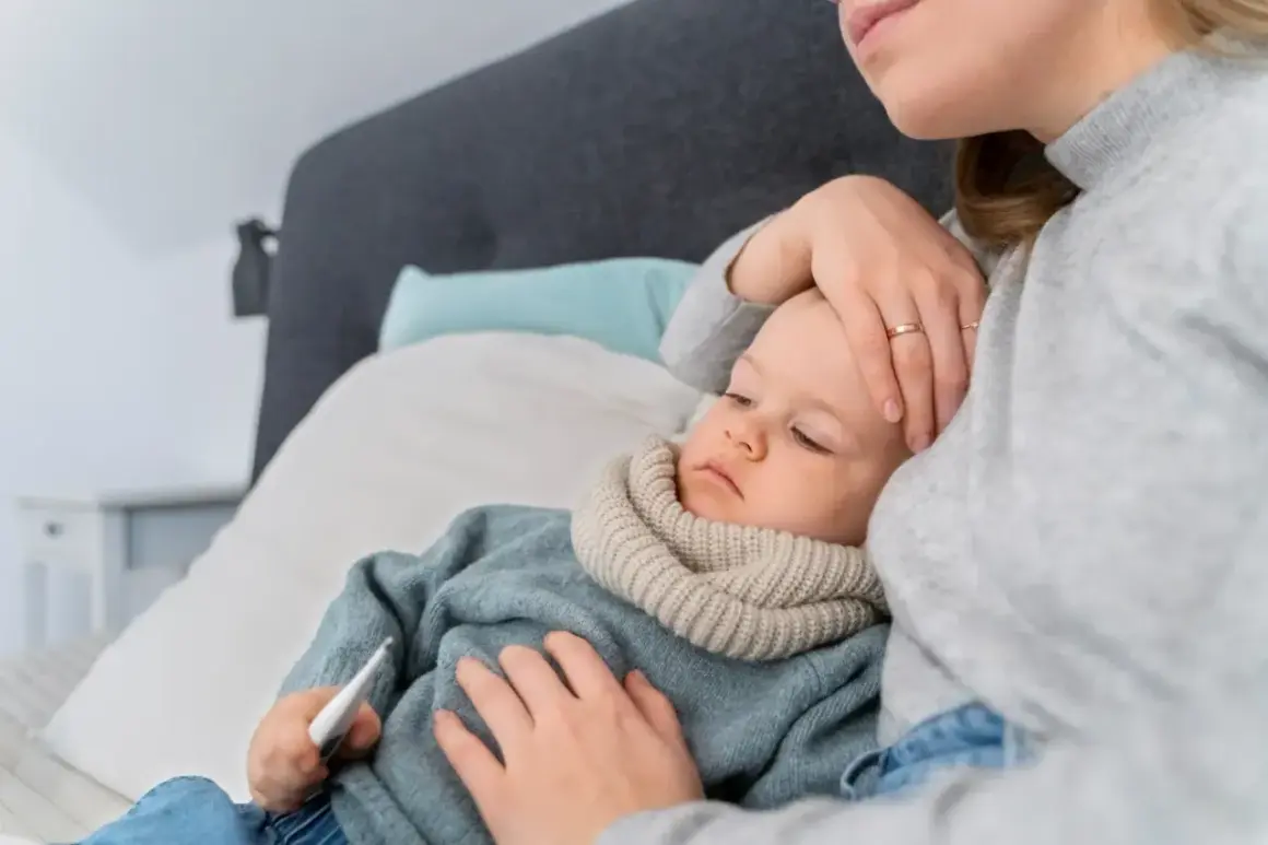 Matka sprawdza temperaturę chorego dziecka, które ma gorączkę.