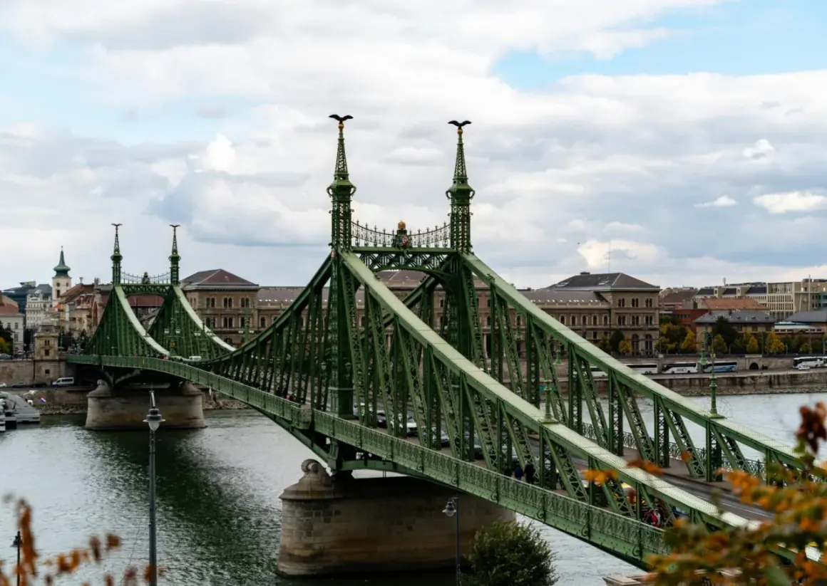 Zielony most w Budapeszcie nad rzeką Dunaj, z charakterystycznymi orłami na szczytach wież.